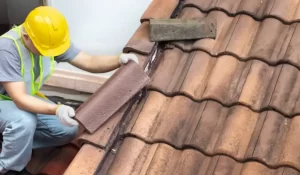 A roofing contractor providing professional roofing services by repairing a leaky roof with precision and care.