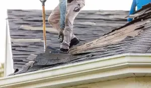 Contractor replacing damaged shingles during emergency roof leak repair in Romeoville.