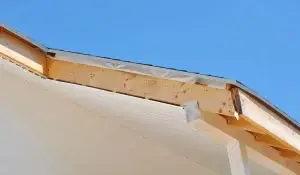 Residential roofline showing exposed fascia and installed soffit panels under a clear sky, illustrating potential vulnerability to damage.