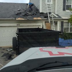 Roof installation in Romeoville, IL with contractors removing old shingles and preparing for a new roof.