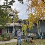 Roof replacement materials being lifted onto the home while DNS Exterior roofing crew works on tear-off in Lockport, IL.