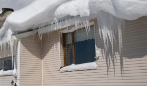 Roof ice dam with heavy icicles causing winter roof damage on a Lockport Illinois home.